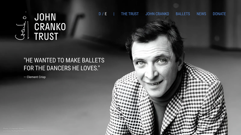 Startseite des John Cranko Trust: Schwarz-Weiß-Porträt von John Cranko im karierten Sakko neben dem Zitat „He wanted to make ballets for the dancers he loves.“ von Clement Crisp.